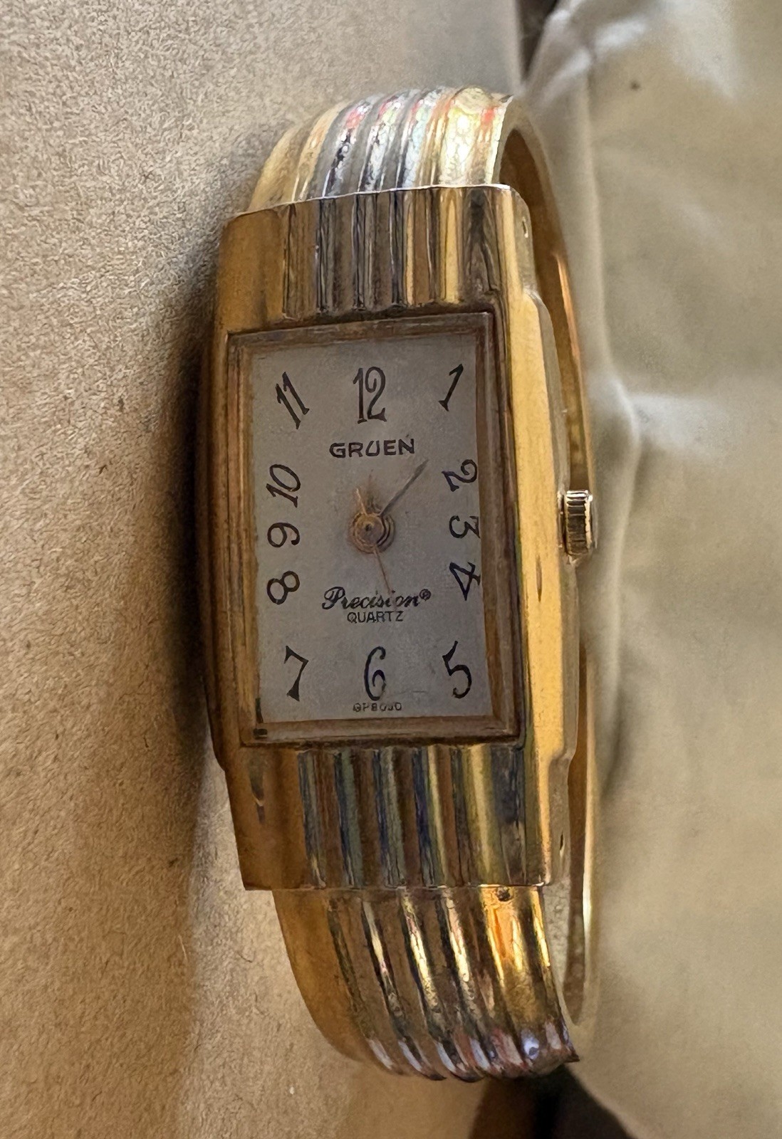 Gruen women’s Wristwatch With chunky gold-tone hinged cuff bangle.