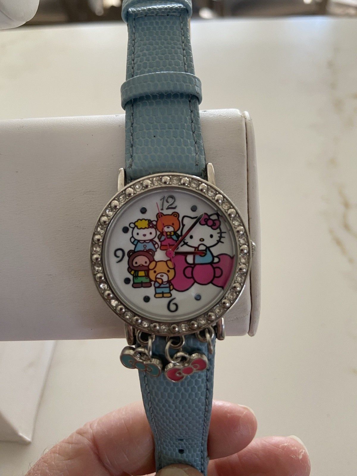 Hello Kitty watch with a light blue faux leather strap and rhinestone bezel Runs